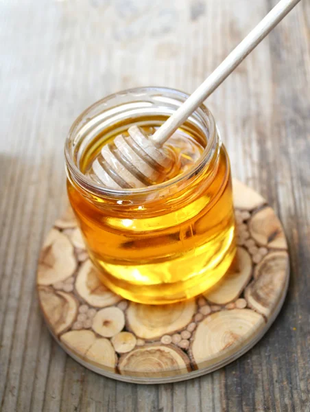 Golden honey with honeystick. cinnamon and anise stars on wooden table — Stock Photo, Image