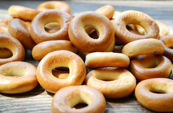 Lots of small dry bagels on wooden table — Stock Photo, Image