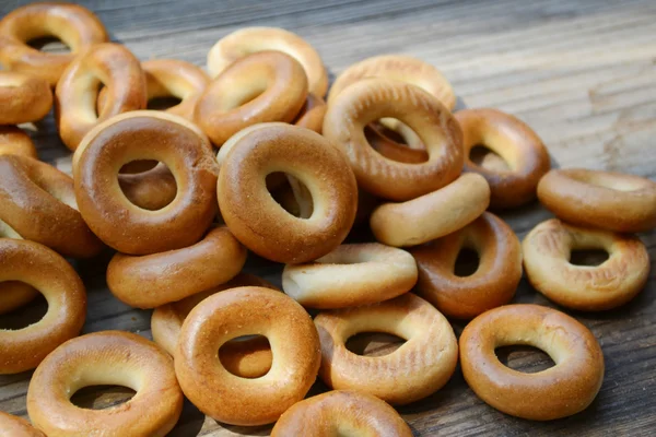 Lots of small dry bagels on wooden table — Stock Photo, Image