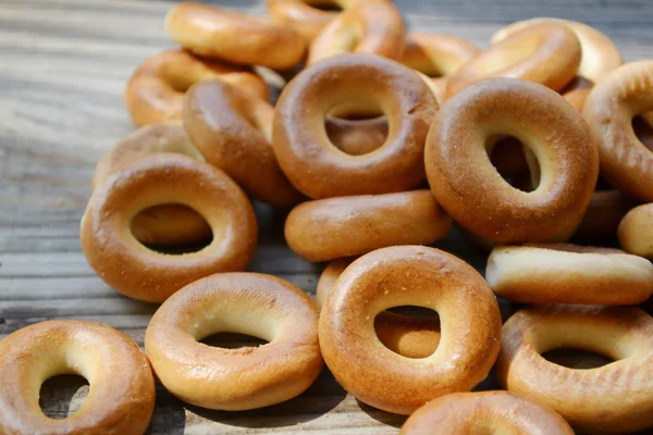 Beaucoup de petits bagels secs sur une table en bois — Photo