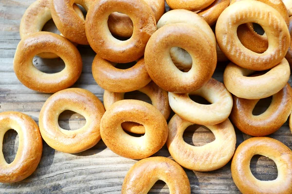 Massor av små torra bagels på träbord — Stockfoto