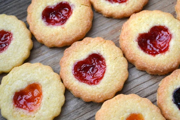 Galletas caseras con mermelada en forma de corazón en mesa de madera — Foto de Stock