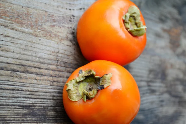 木製のテーブルに美味しいオレンジ柿 — ストック写真