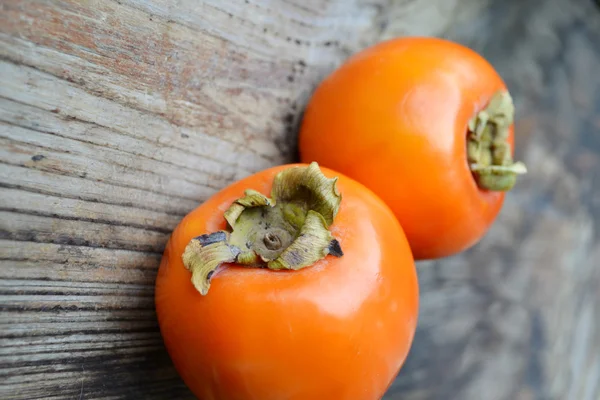 Heerlijke oranje kaki op houten tafel — Stockfoto