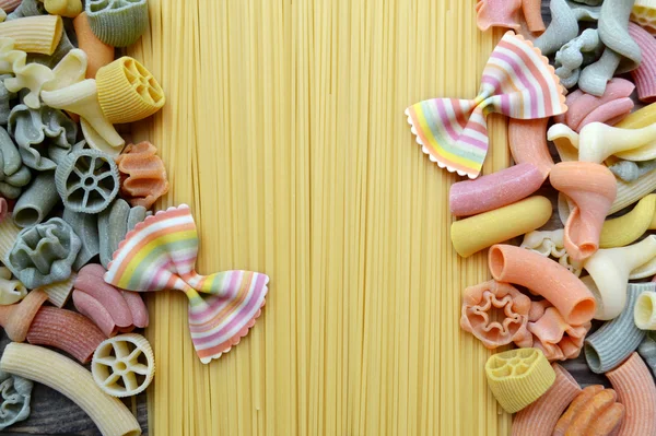 Conjunto de diferentes tipos de massas italianas coloridas na mesa de madeira — Fotografia de Stock