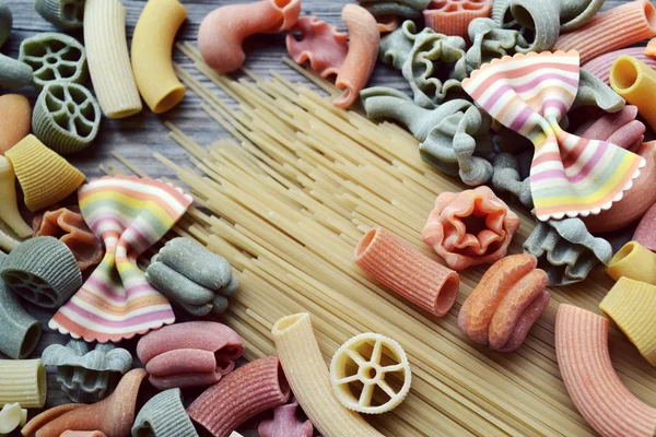 Conjunto de diferentes tipos de massas italianas coloridas na mesa de madeira — Fotografia de Stock