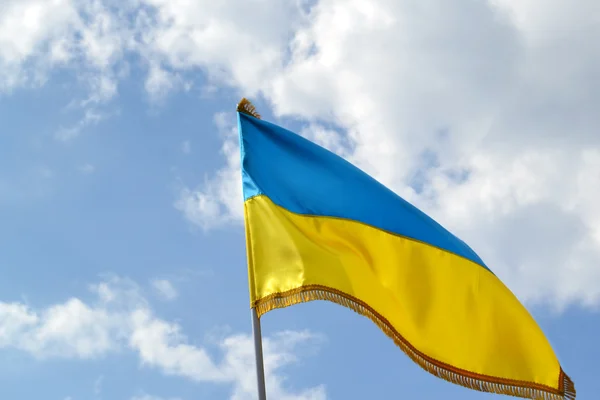 Le drapeau national jaune et bleu de l'Ukraine sur le ciel et les nuages — Photo