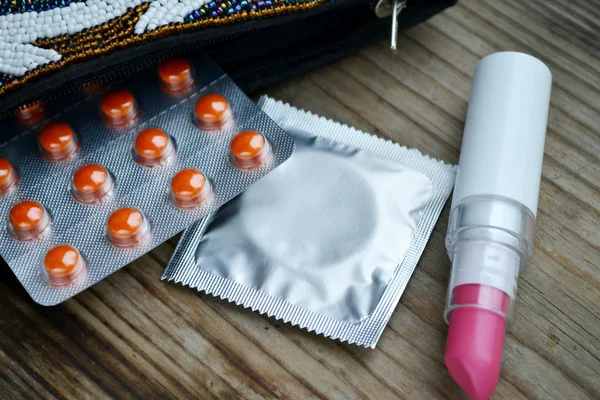 Prezervatif ve bir kozmetik ile pembe ruj ve kirpik kıvırıcı ayarla — Stok fotoğraf