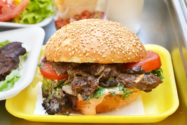 Leckere Burger mit Fleisch, Salat und Tomaten — Stockfoto