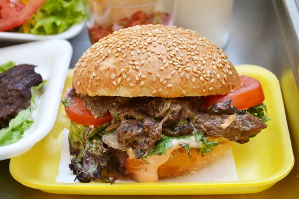 Hambúrguer saboroso com carne, salada e tomate — Fotografia de Stock