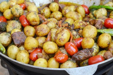Kızarmış patates, et ve domates ile büyük kazan