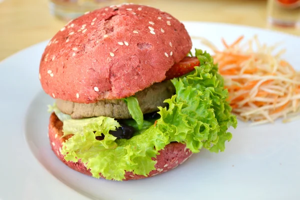 Leckerer rosa Burger mit Fleisch, Salat und Erdbeere — Stockfoto