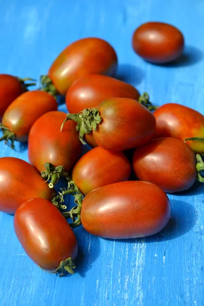 Parlak mavi zemin üzerine büyük koyu kırmızı domates — Stok fotoğraf