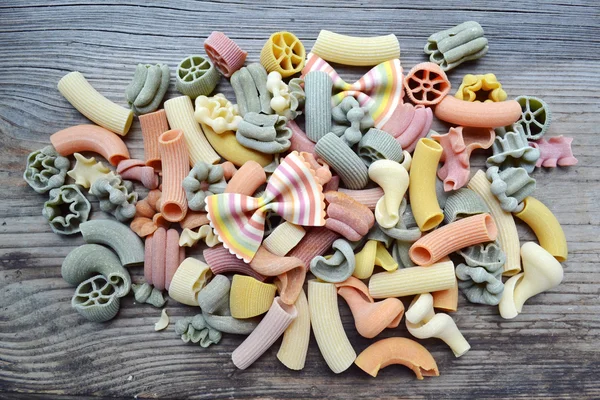 Conjunto de diferentes tipos de massas italianas coloridas na mesa de madeira — Fotografia de Stock