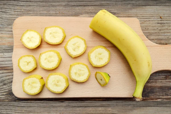 Gelbe Bananenscheiben auf Holzbrett — Stockfoto