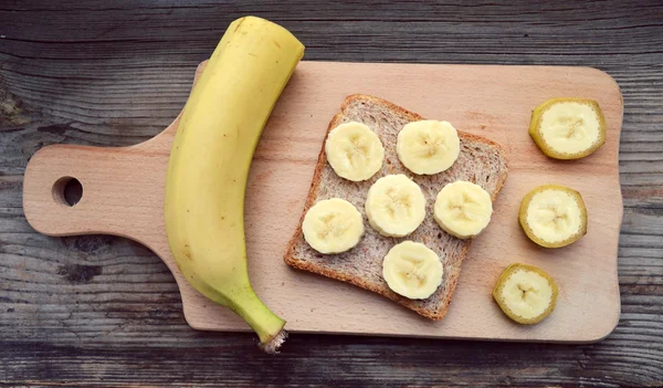 Gesundes Toast mit Banane auf Holzbrett — Stockfoto