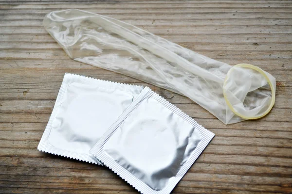 Par av kondomer på träbord — Stockfoto
