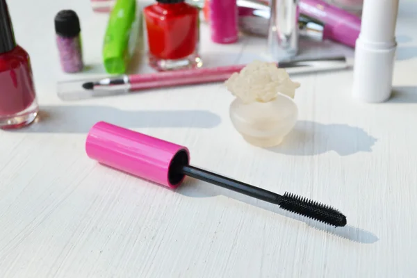 Pink mascara stick, eyeliner, lipstick, pencil and other cosmetics on the white dressing table — Stock Photo, Image