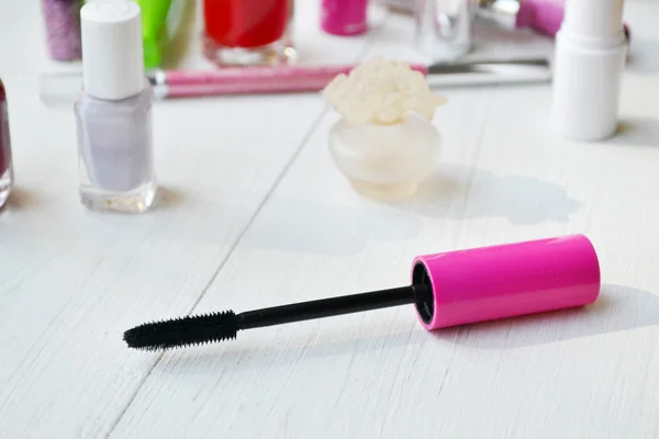 Pink mascara stick, eyeliner, lipstick, pencil and other cosmetics on the white dressing table — Stock Photo, Image