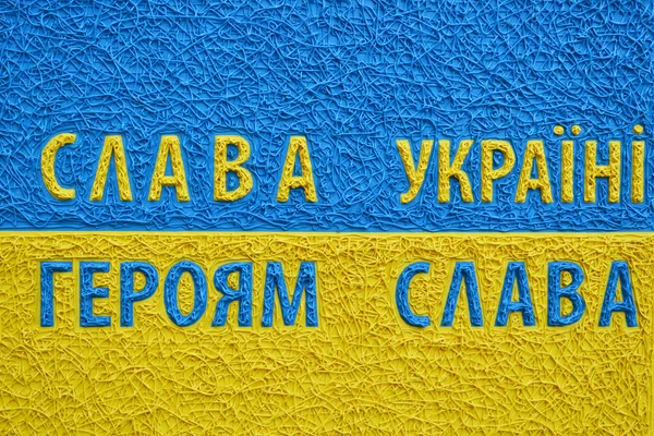 The famous ukrainian tagline Glory to Ukraine! Glory to the heroes in national yellow and blue colours. A symbol of Ukraine. — Stock Photo, Image