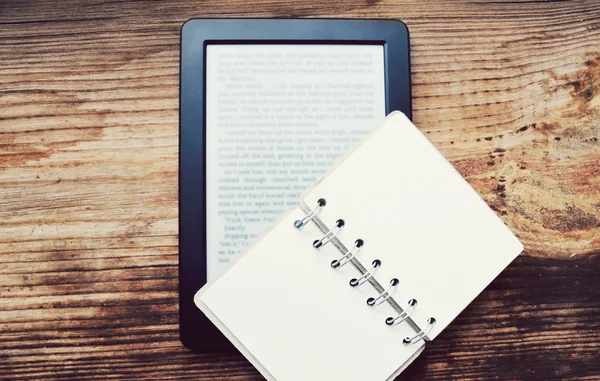 Black ereader with a small old notebook on wooden table — Stock Photo, Image