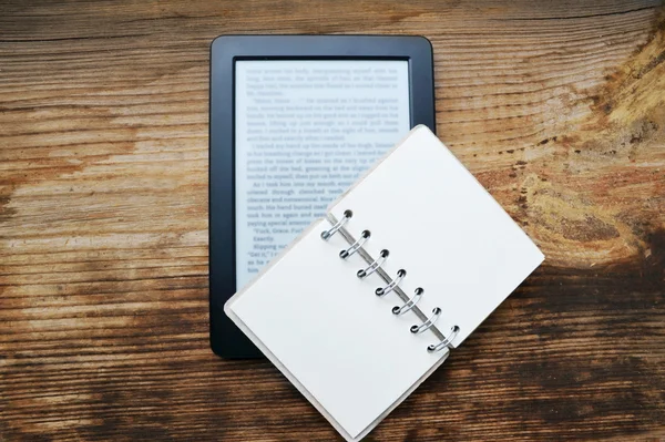 Black ereader with a small old notebook on wooden table — Stock Photo, Image