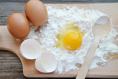 yumurta, tereyağı ve tahta kaşık yemek kartı üzerindeki beyaz un