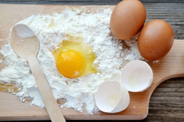 yumurta, tereyağı ve tahta kaşık yemek kartı üzerindeki beyaz un