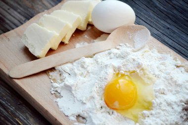 yumurta, tereyağı ve tahta kaşık yemek kartı üzerindeki beyaz un