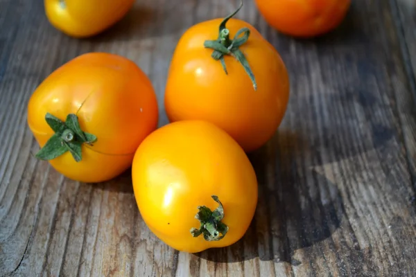 Big yellow tomatoes on old wooden background — Stock Photo, Image