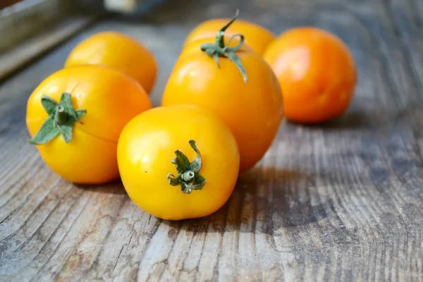 Big yellow tomatoes on old wooden background — Stock Photo, Image