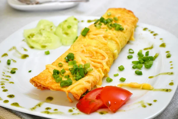 Leckeres Omelett mit Käse und grünen Zwiebeln serviert mit Tomaten auf einem weißen Teller — Stockfoto