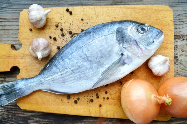 Pişmemiş dorado balık sarımsak ve soğan ile — Stok fotoğraf