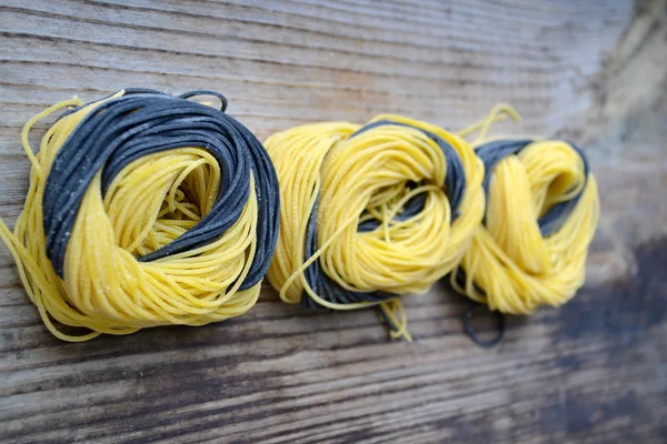 Färgglada okokt italiensk pasta på träbord — Stockfoto