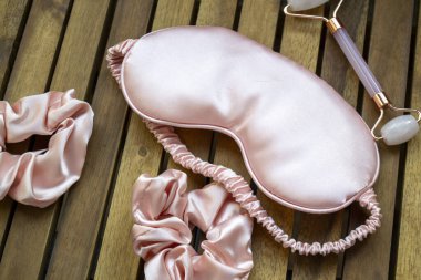 Yumuşak ipeksi pembe uyku maskesi, saç tokası ve kuvars silindirli.