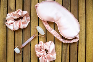 Yumuşak ipeksi pembe uyku maskesi, saç tokası ve kuvars silindirli.