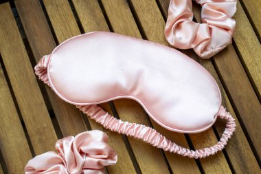 Yumuşak ipeksi pembe uyku maskesi ve saç tokası.