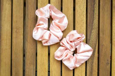 yumuşak ipeksi pembe saç tokası ahşap arka planda