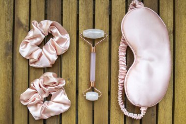 Yumuşak ipeksi pembe uyku maskesi, saç tokası ve kuvars silindirli.