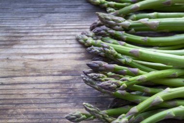 Tahta arka planda taze, yeşil, sağlıklı, çiğ kuşkonmaz.