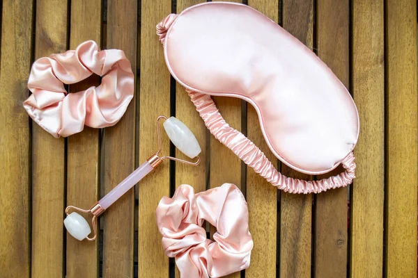 Yumuşak ipeksi pembe uyku maskesi, saç tokası ve kuvars silindirli.