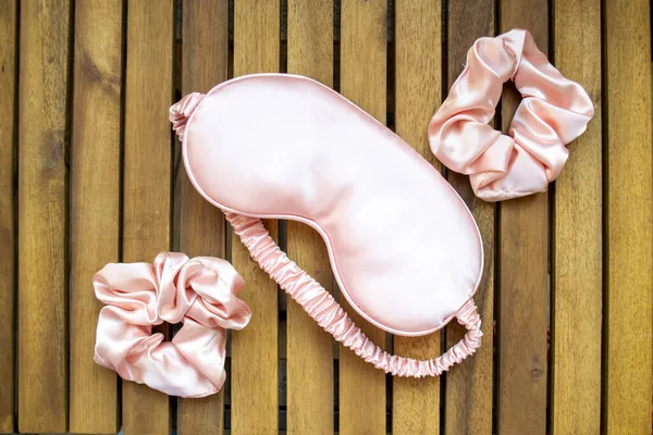 Yumuşak ipeksi pembe uyku maskesi ve saç tokası.