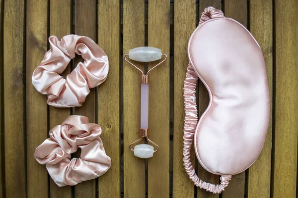 Yumuşak ipeksi pembe uyku maskesi, saç tokası ve kuvars silindirli.