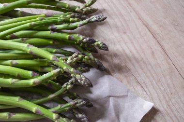 Tahta arka planda taze, yeşil, sağlıklı, çiğ kuşkonmaz.