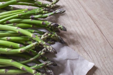Tahta arka planda taze, yeşil, sağlıklı, çiğ kuşkonmaz.