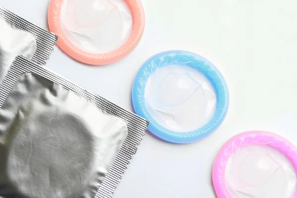 Couple of colorful condoms isolated on white — Stock Photo, Image