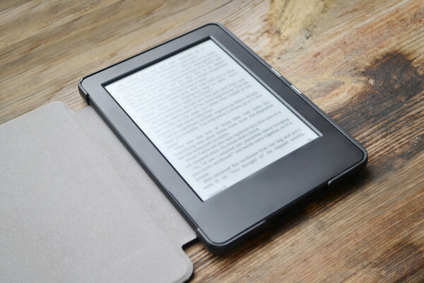 Black ereader on wooden table