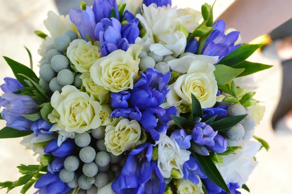 Hermosa novia sosteniendo un ramo de boda de albaricoque y rosas azules — Foto de Stock