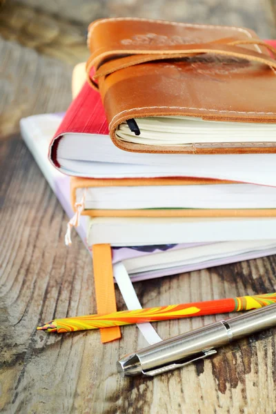 Pile de livres et stylos sur bureau en bois — Photo