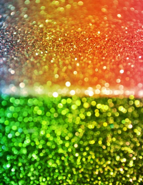 Bright and abstract blurred green background with colorful rainbow shimmering glitter — Stok fotoğraf